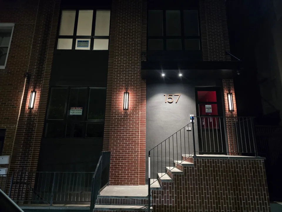 Illuminated brick entrance at 157 25th Street in Brooklyn at night