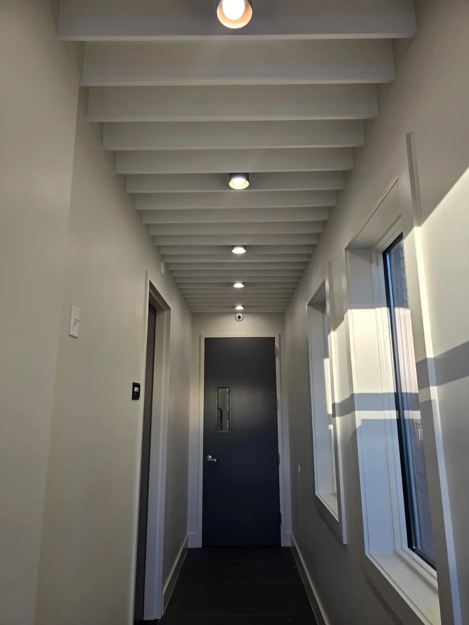 Illuminated hallway and ceiling beams at 157 25th Street, Brooklyn