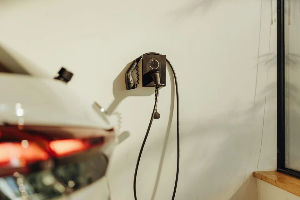 Service example: a wall-mounted EV charger installed beside a parked car