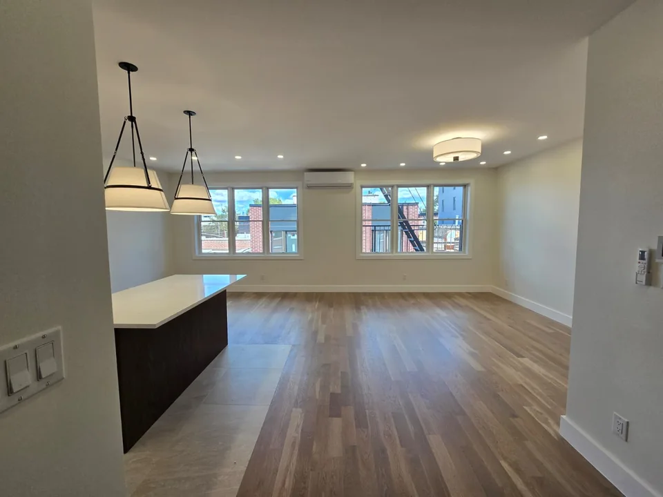 Residential living and kitchen area with pendant fixtures and recessed ceiling lighting